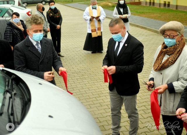 symboliczne przecięcie wstęgi podczas uroczystego przekazania nowego busa dla DPS 