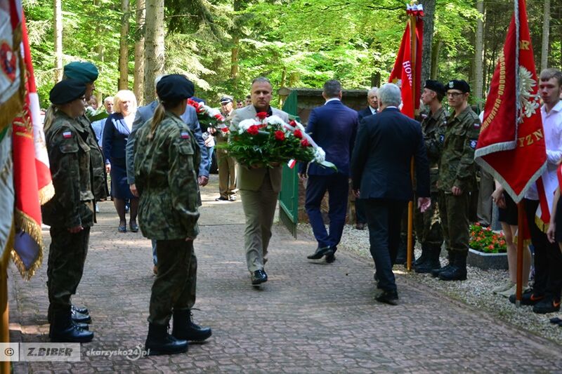 starosta i przewodniczący rady skladają wiązankę kwiatów  