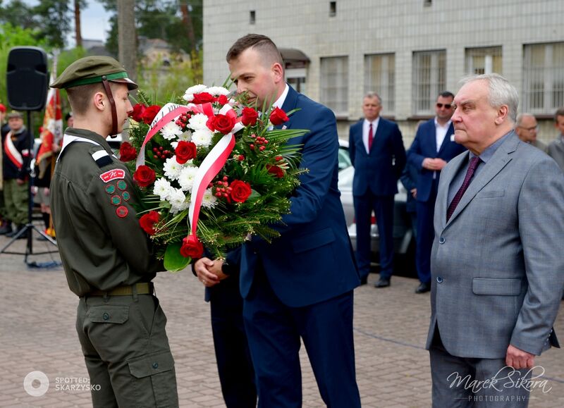 władze powiatu skladają wiązankę kwiatów