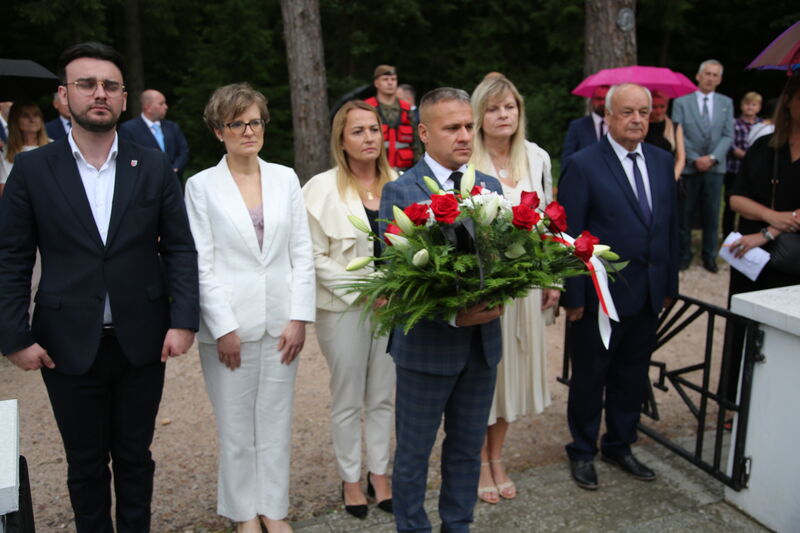 Delegacja władz powiatu skarżyskiego składająca wiązankę na mogile pomordowanych na Brzasku. 