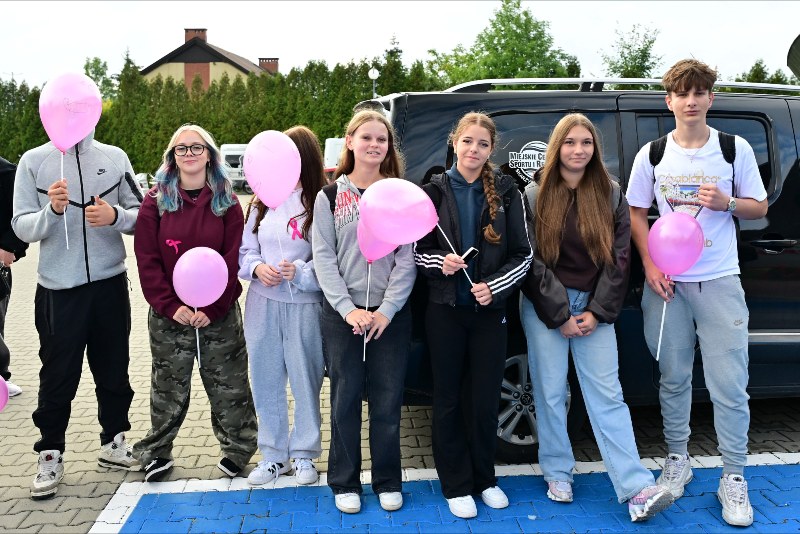 grupa młodzierzy z balonami pozująca do zdjęcia