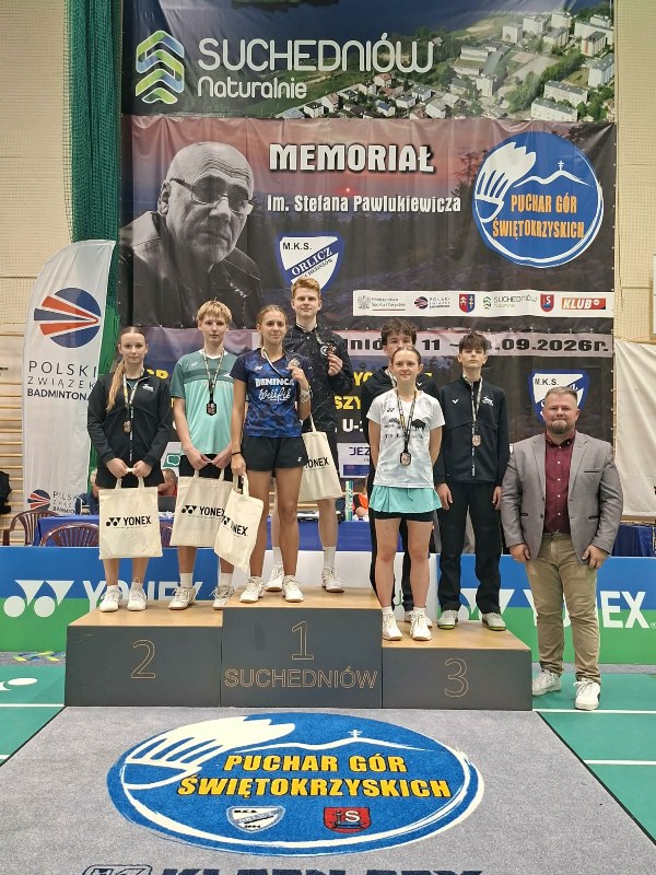 zawodnicy na podium w asyście organizatora