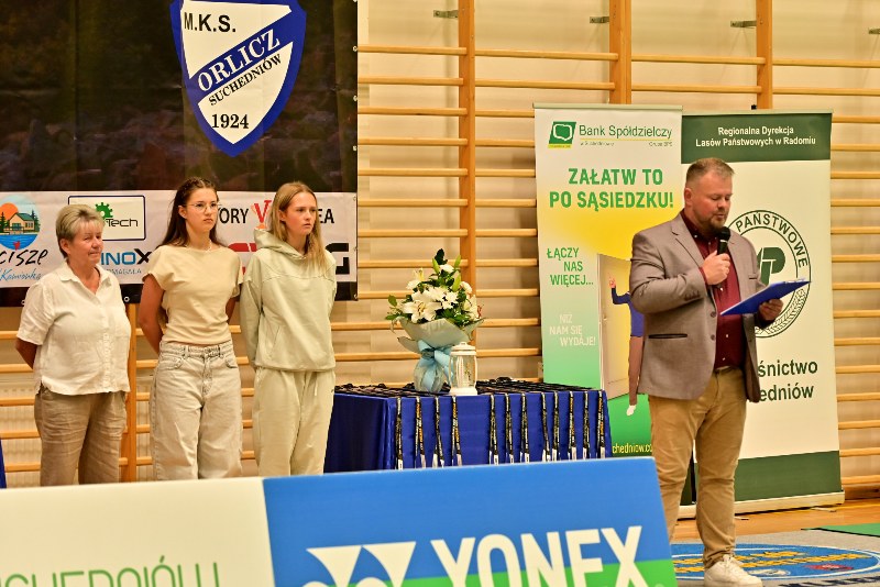 mężczyzna z mikrofonem, 3 kobiety w białych koszulkach