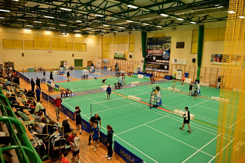 szerokie ujęcie hali sportowej z góry, przedstawiające zawodników grających w badmitona