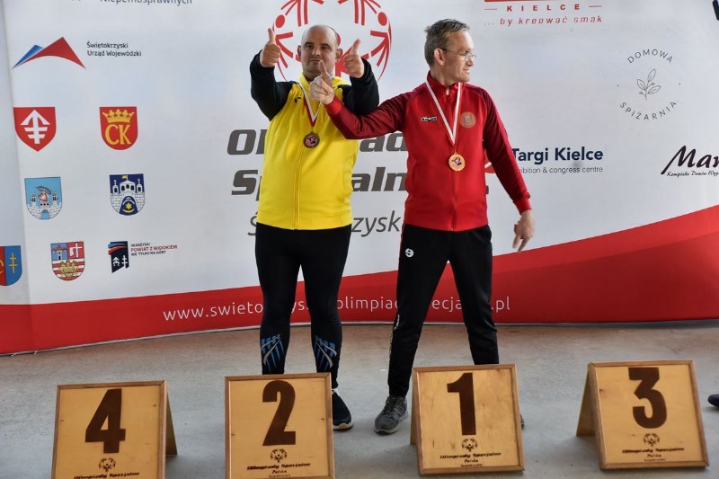 2 mężczyzn z medalami na podium
