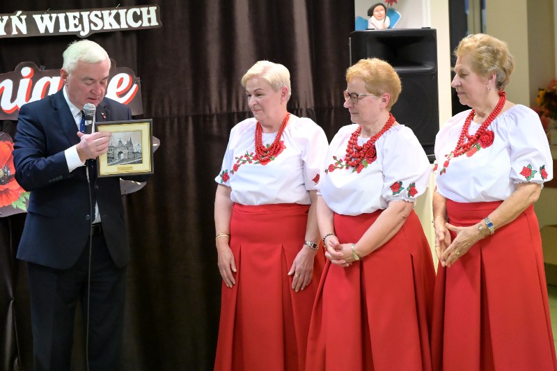 Przewodniczący Sejmiku Województwa Świętokrzyskiego Andrzej Bętkowski wręcza prezent 3 członkiniom KGW Łącznianie
