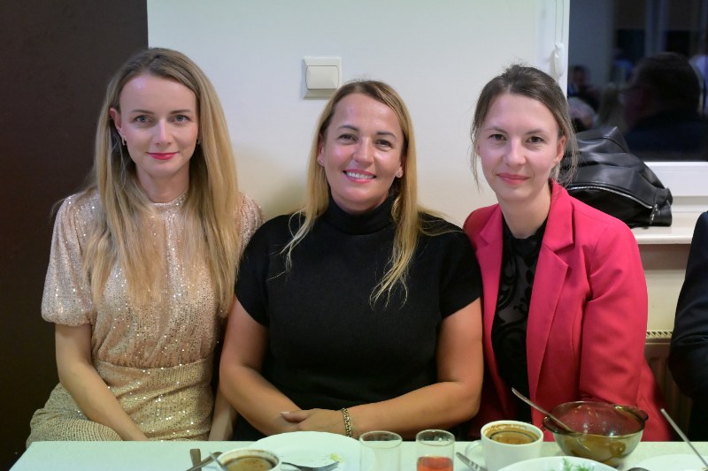 3 uśmiechnięte kobiety za stołem